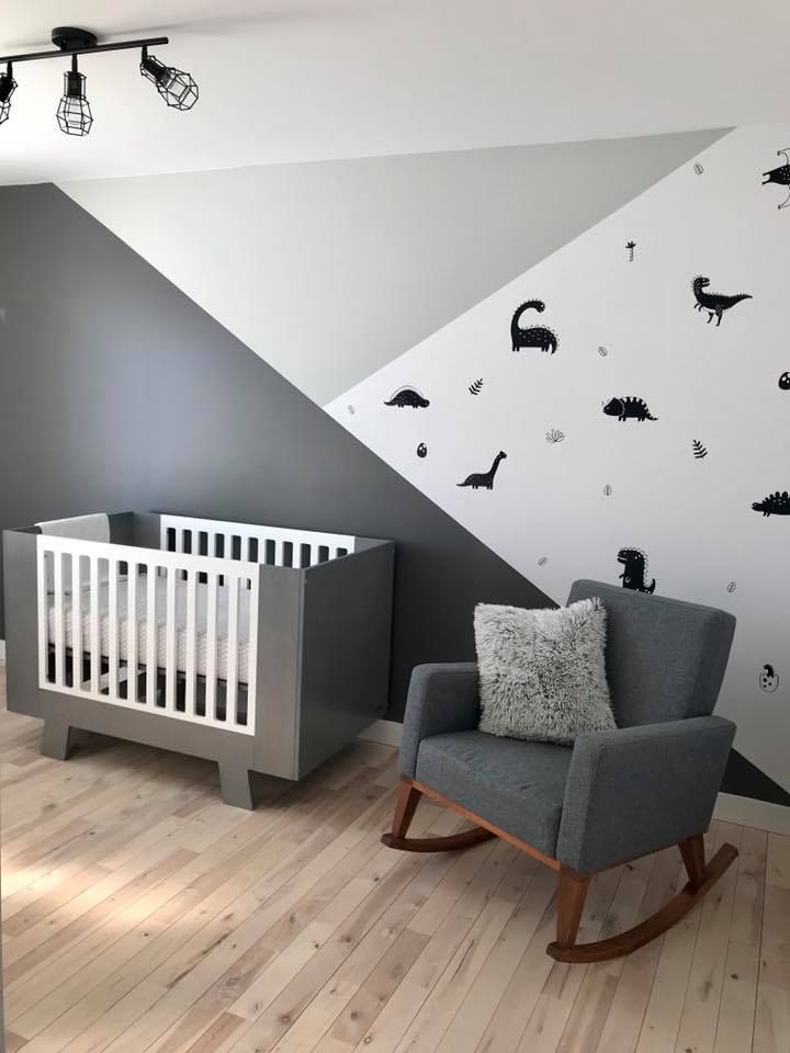 a baby's room with a rocking chair, crib and wall decals