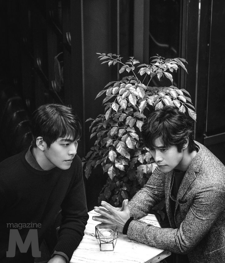 two young men are sitting at a table