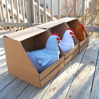 two stuffed chickens in a cardboard box on a deck