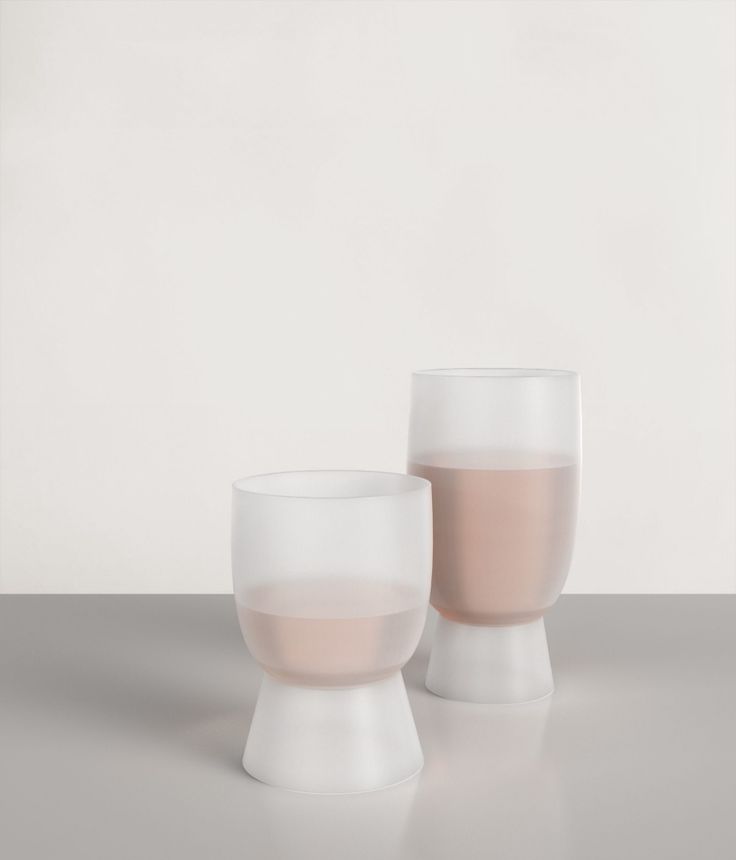 two white and pink vases sitting on top of a table