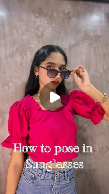 a woman in pink shirt and jeans holding up her sunglasses with the words how to pose in sun glasses