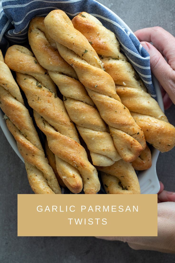 garlic parmesan twists in a white bowl with a blue and white striped towel