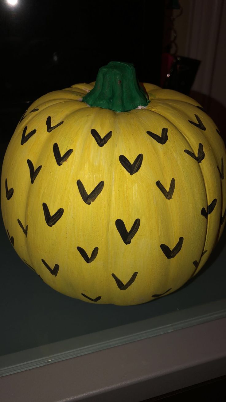 a yellow pumpkin with black arrows painted on it