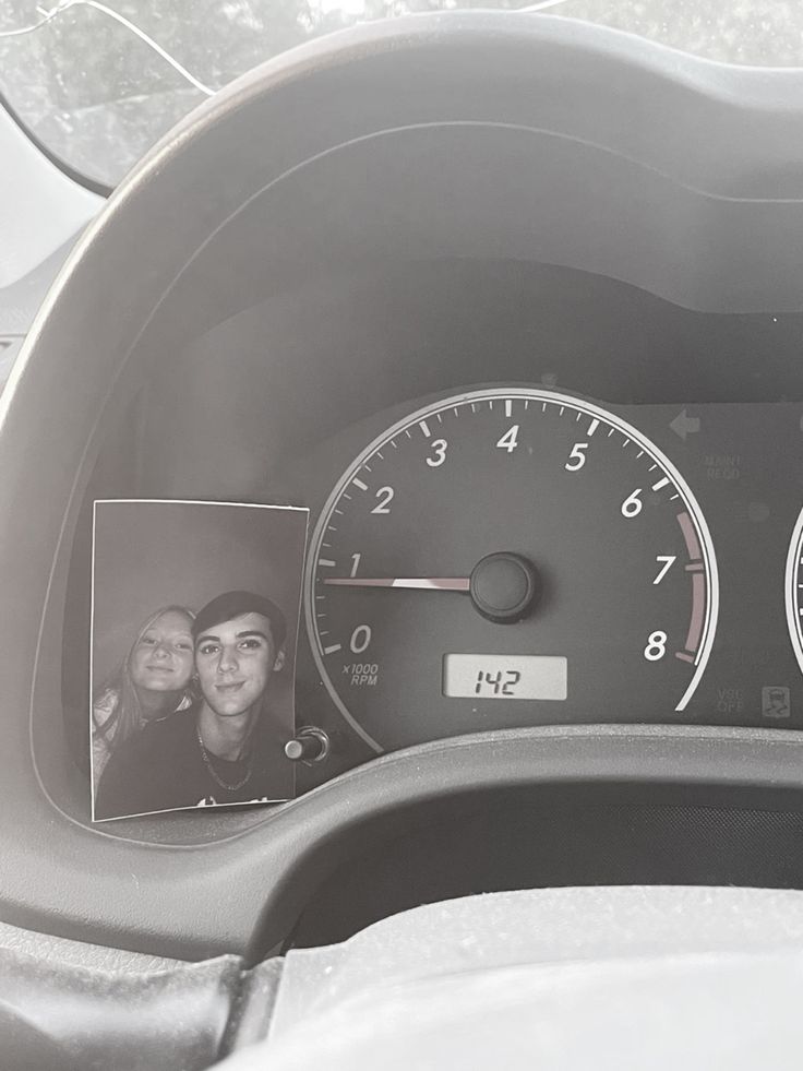 the dashboard of a car with two pictures on it