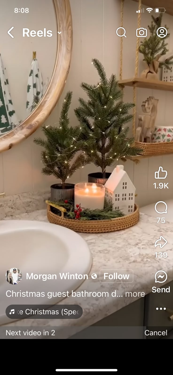 a christmas tree in a basket next to a bathroom sink with candles on the counter