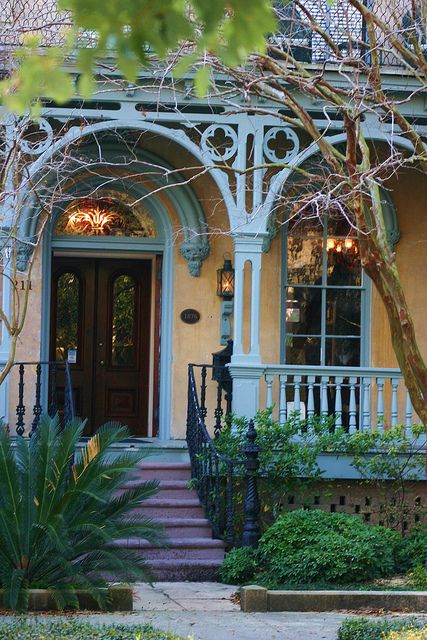 the front door of a house with wrought iron railings and stairs leading up to it