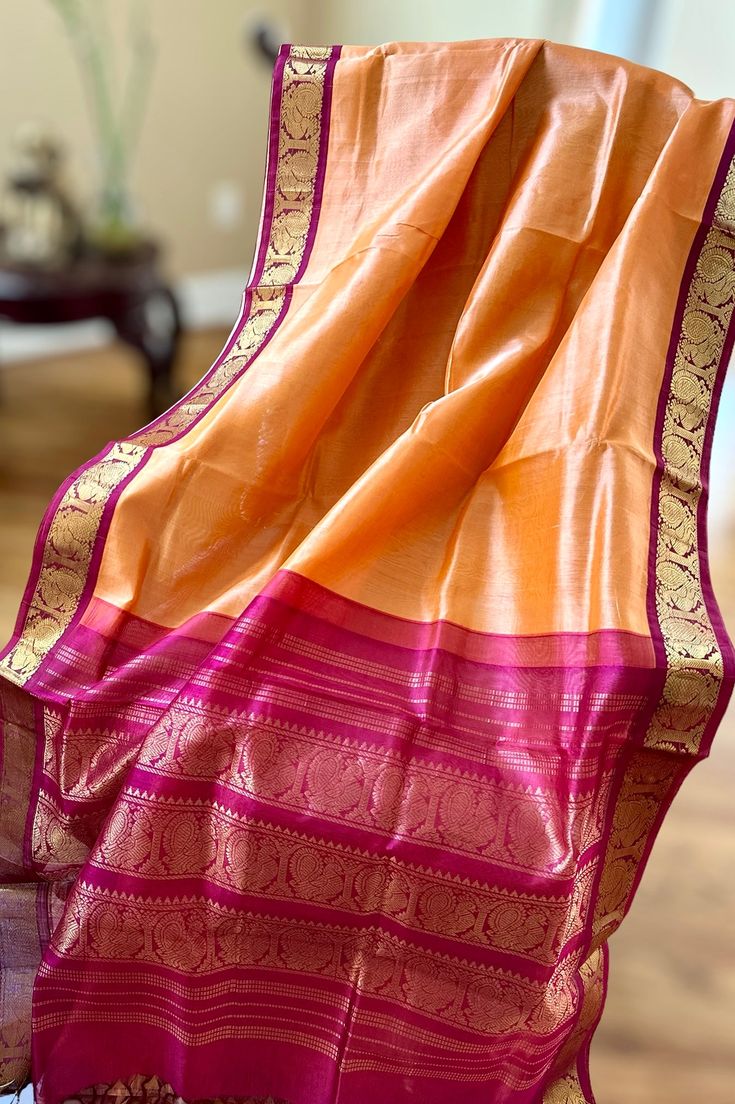 This regal korvai silk cotton saree in peach sorbet with maroon border and pallu is handwoven. The saree borders are adorned with traditional motifs in gold zari. The maroon pallu is grand with a rich gold zari work. Approximate Length 6.5 mtrs (inclusive of blouse length) Approximate weight - 1.2 lbs Approximate Height - 48 - 50" Saree comes with fall, picot and tassels done when applicable. Blouse piece is cut. Kindly Note : The colors you see on your device may vary due to the color reproduction, brightness and resolution of individual devices. If you'd like more clarity before your purchase, please contact our support team. Saree Borders, Peach Sorbet, Saree Border, Traditional Motifs, Silk Cotton Sarees, Zari Work, Cotton Sarees, Blouse Length, Support Team