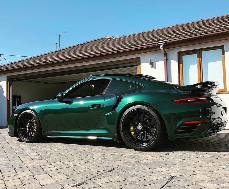 a green sports car parked in front of a house