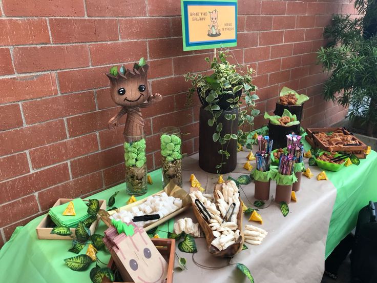 a table topped with lots of plants and potted plants next to a brick wall