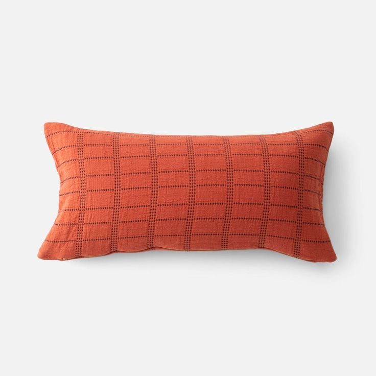 an orange and black pillow on a white background