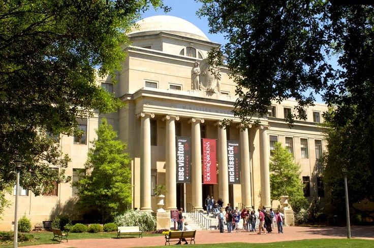 people walking in front of a building with columns