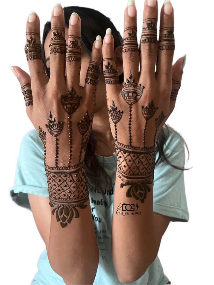 the woman is holding her hands up with hendi tattoos on it's arms