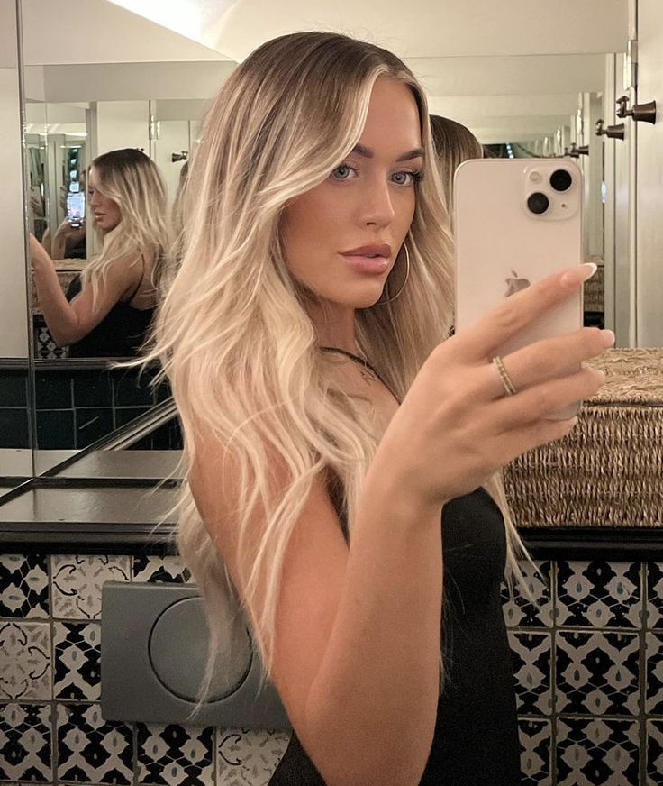 a woman taking a selfie in front of a mirror