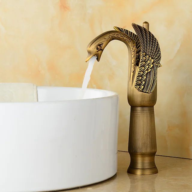 a faucet with water pouring out of it sitting next to a white bowl