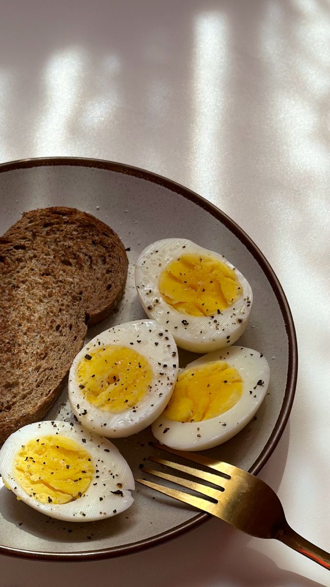 a plate with eggs, toast and butter on it