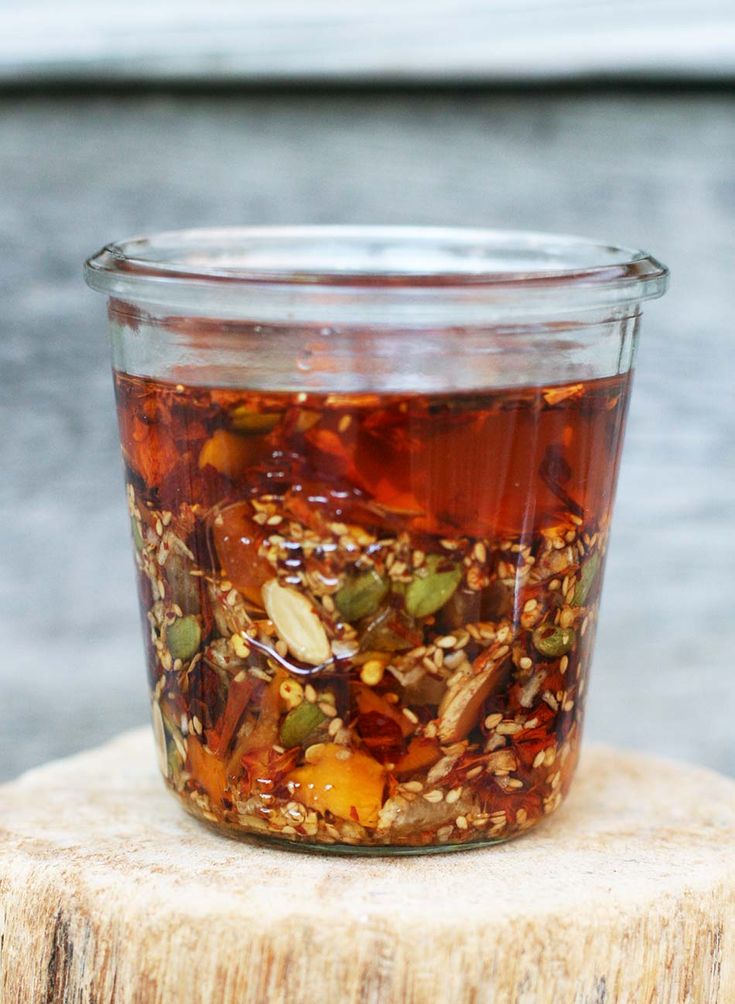 a jar filled with food sitting on top of a tree stump