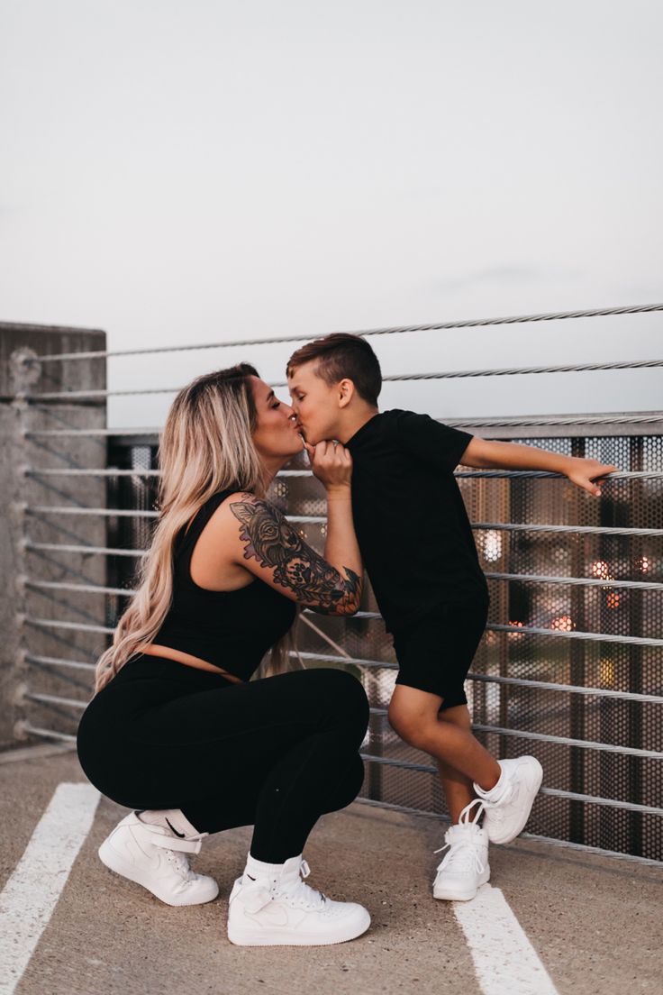 a man and woman kissing on top of a building