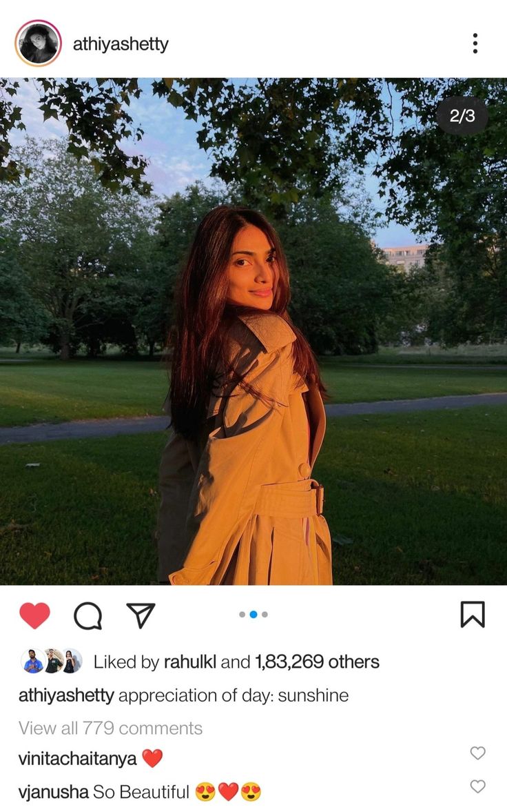 a woman standing in the grass wearing a trench coat