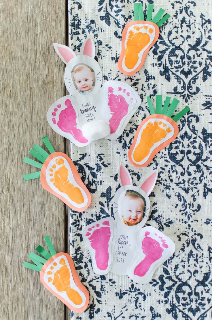 some baby feet and carrots are on the table next to a paper cutout