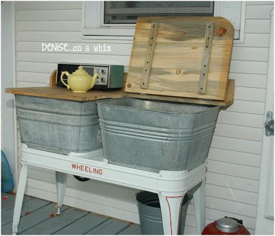 two metal buckets sitting on top of a table next to a yellow pitcher and kettle