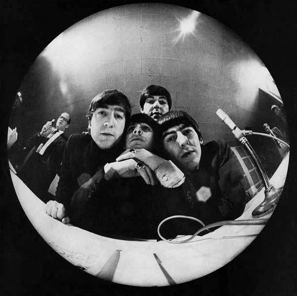 the beatles are reflected in a round mirror