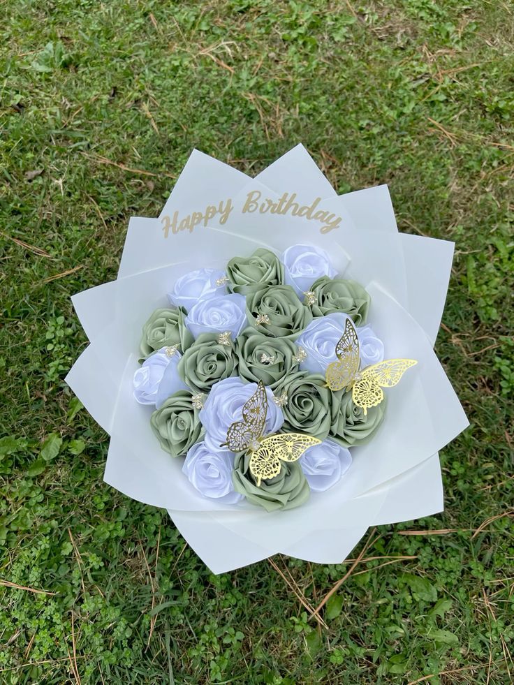 a bouquet of flowers sitting on top of a white plate in the middle of grass