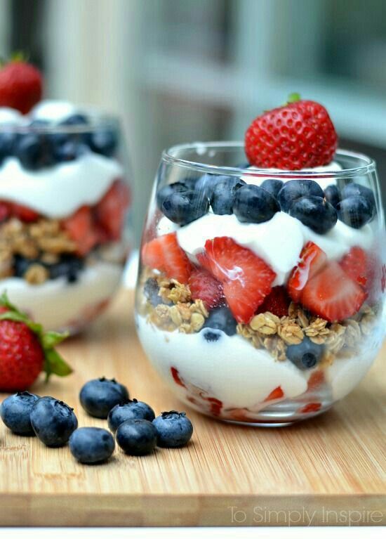 red, white and blue parfaits with yogurt and berries on a cutting board