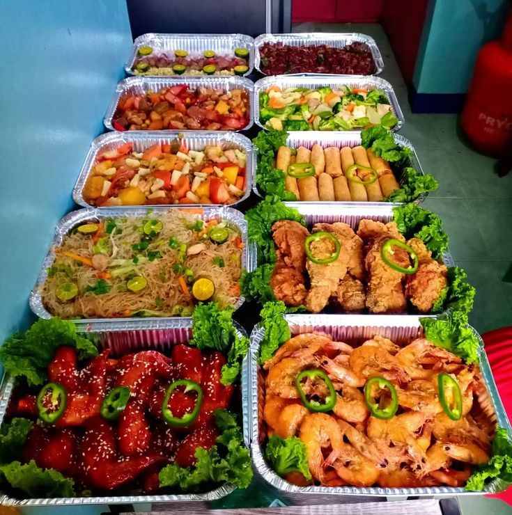 several trays filled with different types of food on top of a table next to each other