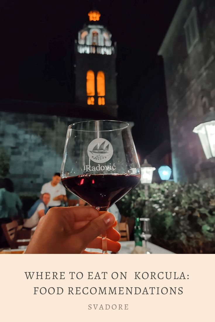 a person holding a glass of wine in front of a building with the words where to eat on koruua food recommendeds