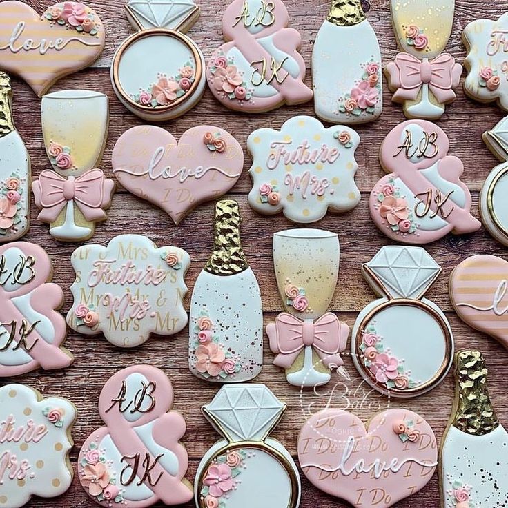 some decorated cookies are on a table with pink and gold decorations in the shape of hearts