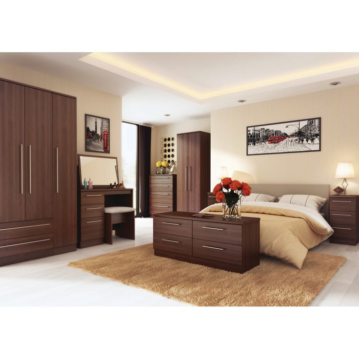 a bedroom with a bed, dressers and mirror in it's center area