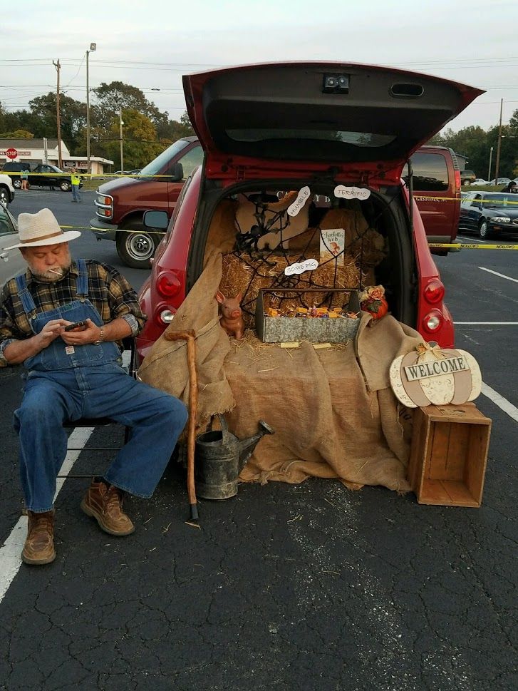 a man sitting in the back of a red truck next to a pile of stuff