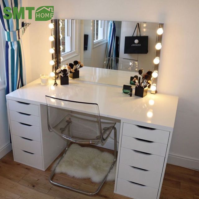 a white desk topped with a mirror and lots of drawers