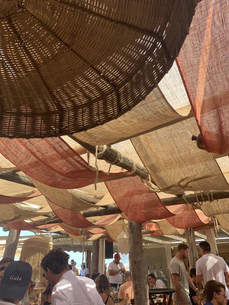 people are sitting under umbrellas at an outdoor restaurant