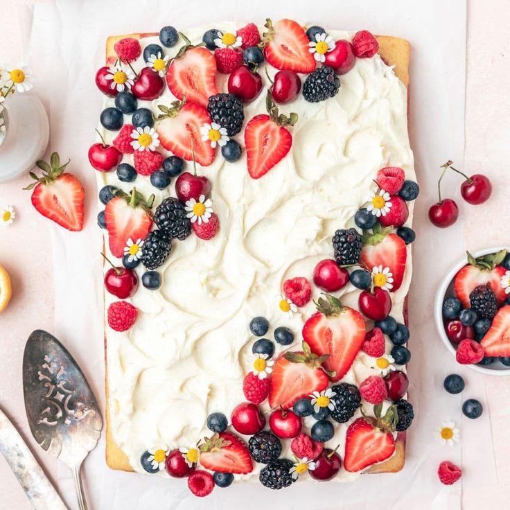 a cake with berries and cream frosting on it