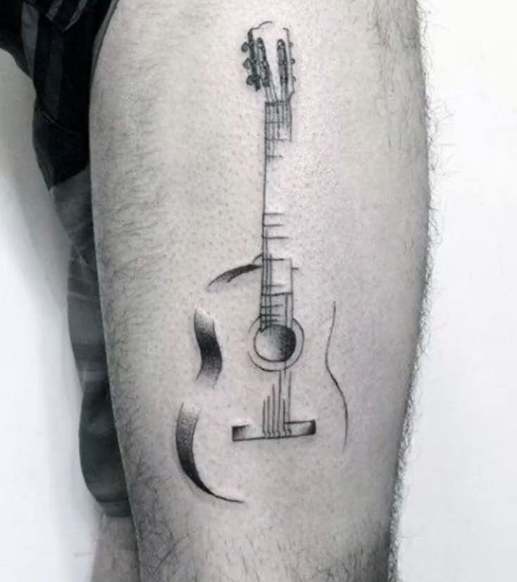 a man with a guitar tattoo on his thigh