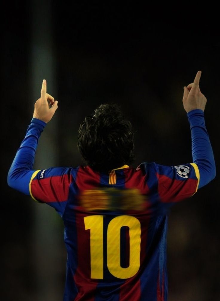 a soccer player with his hands up in the air while wearing a blue and red uniform