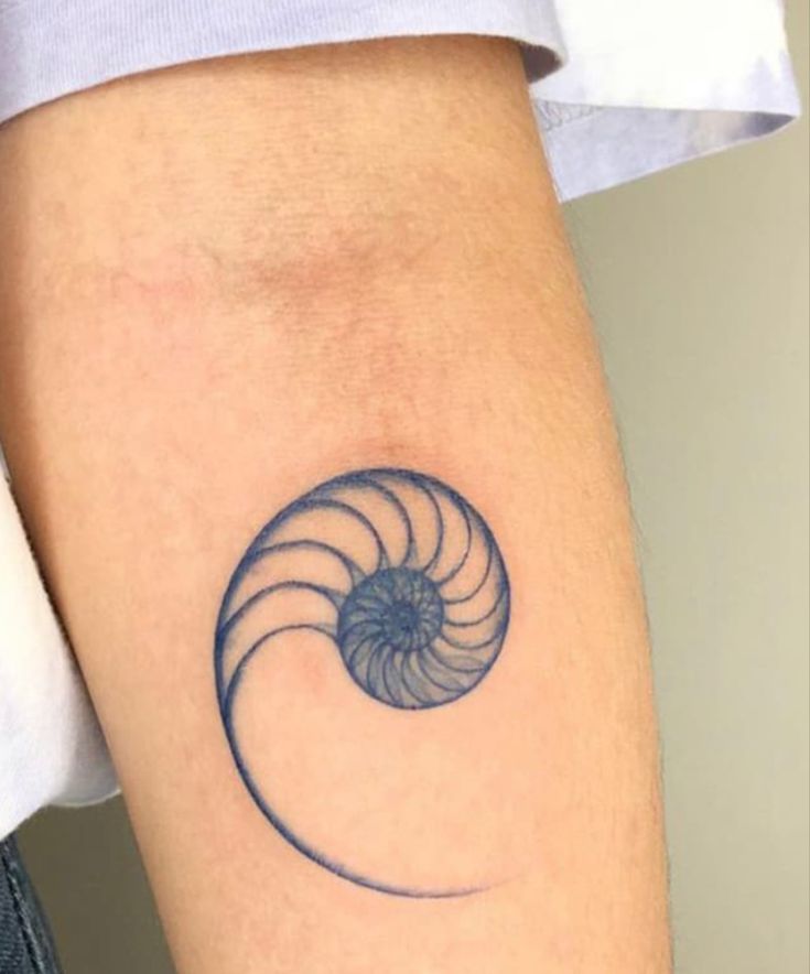 a woman's arm with a tattoo on it that is shaped like a spiral