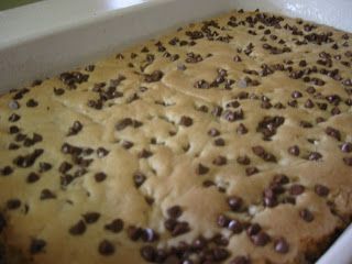 a loaf of bread with chocolate chips on it sitting in a white baking dish, ready to be baked