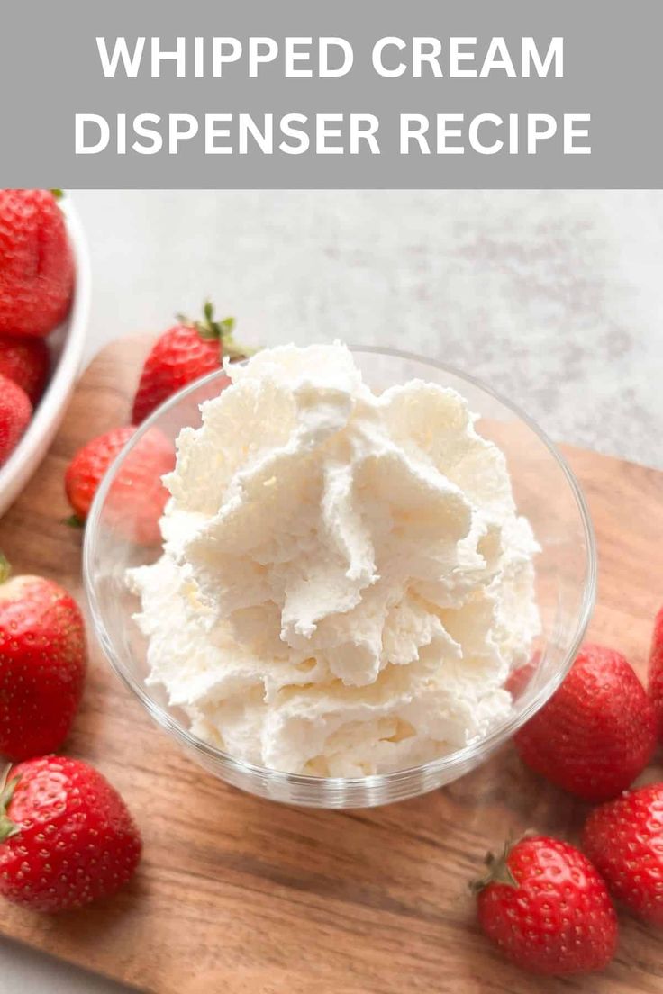 whipped cream in a glass bowl with strawberries around it on a wooden cutting board