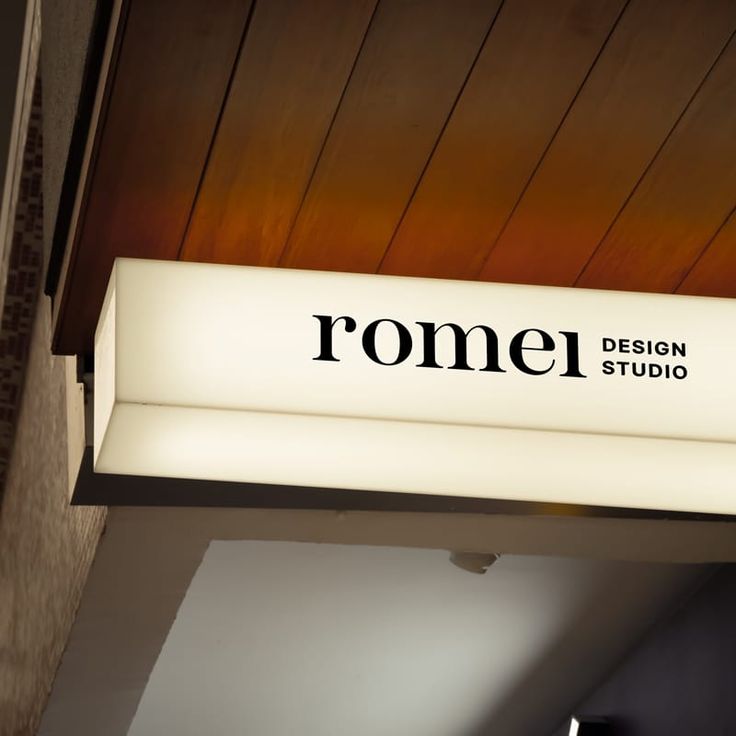 a sign hanging from the side of a building that says rome design studio on it