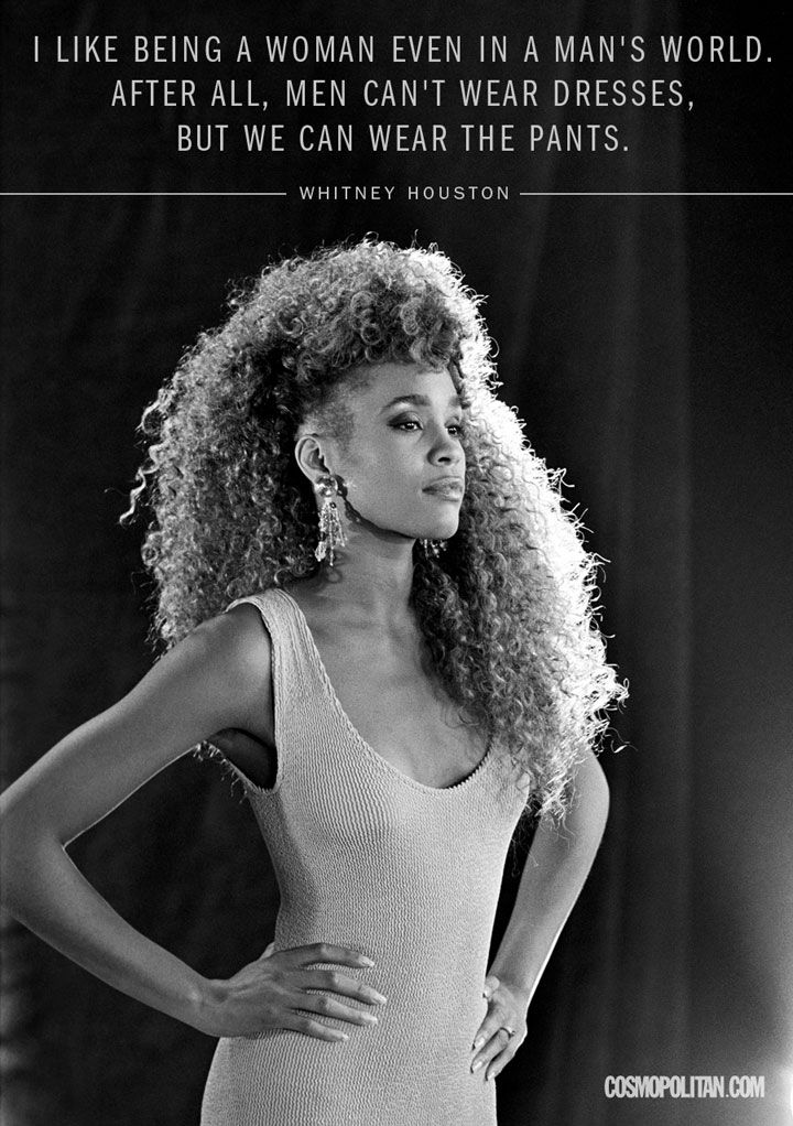 a black and white photo of a woman with long curly hair, wearing a tank top