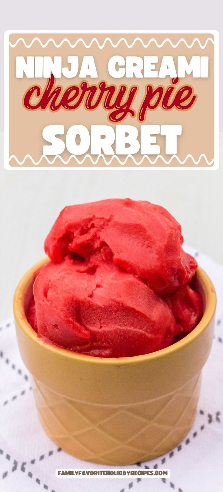 a bowl filled with red ice cream on top of a white table cloth next to a sign that reads, nija cream cherry pie sorbet