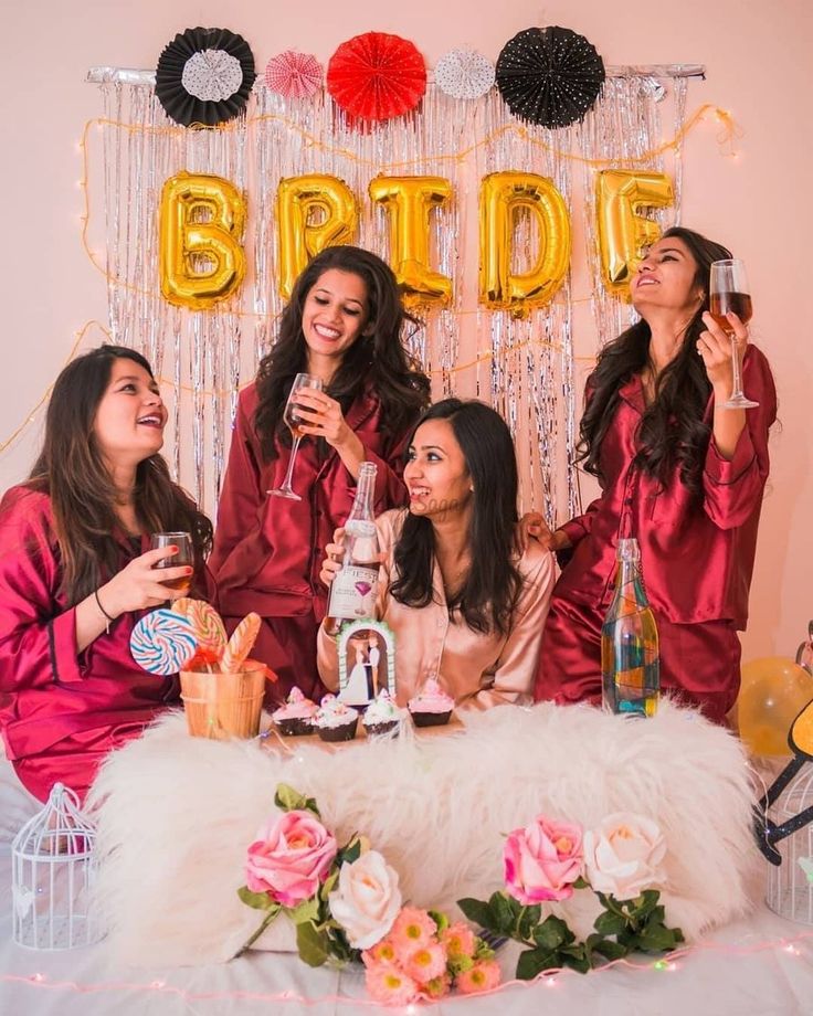 the bride and her bridesmaids pose for a photo in front of their balloons