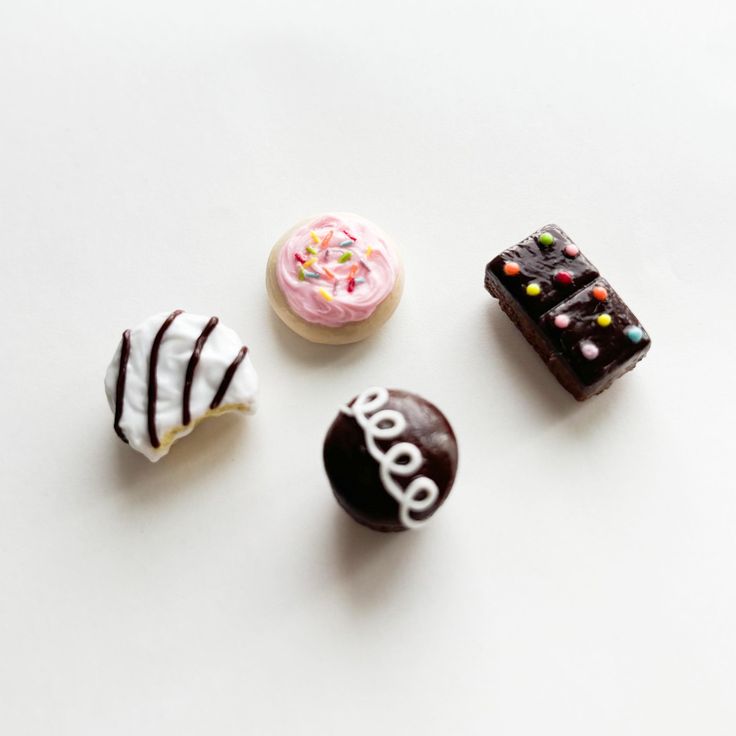 four different types of donuts on a white surface