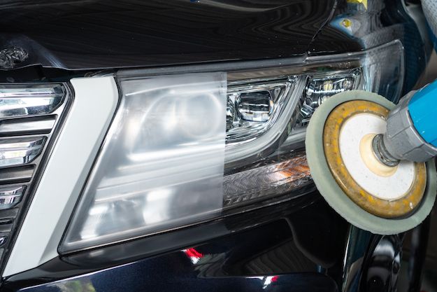 a close up of a car being waxed with a sponge and a machine tool