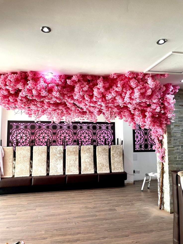 a room with pink flowers on the ceiling and chairs in front of an open area