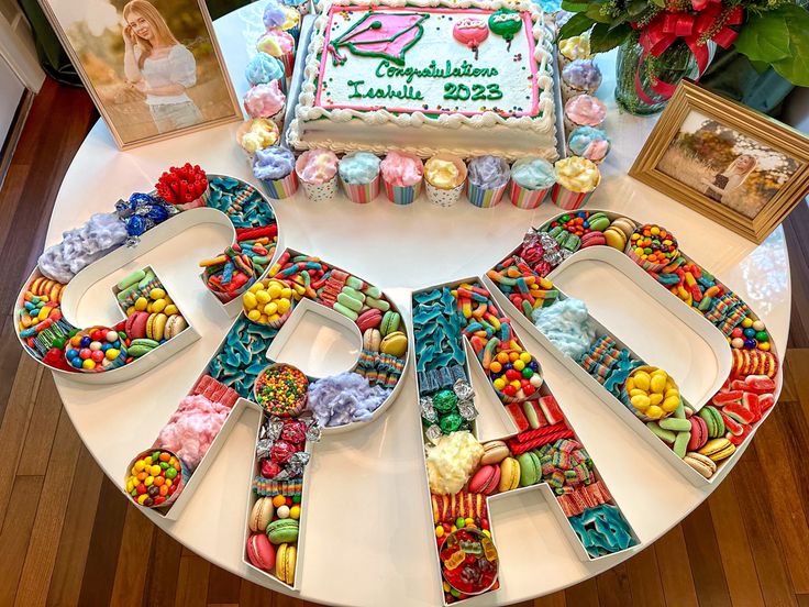 a birthday cake with the number twenty seven surrounded by candies and other candy items