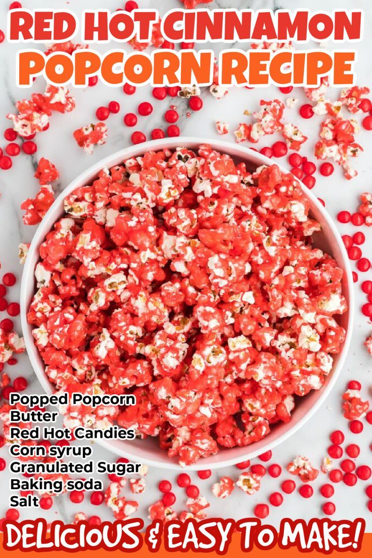 a white bowl filled with red and white popcorn kernels on top of a table