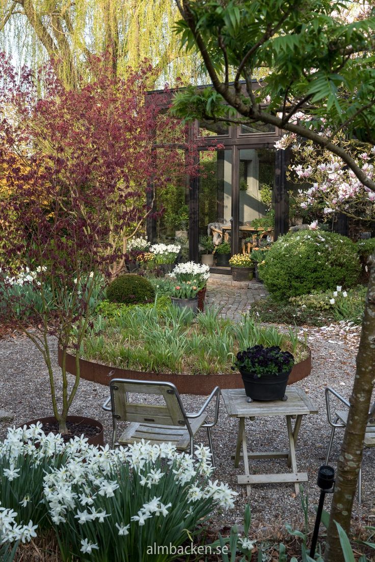 the garden is full of flowers and trees